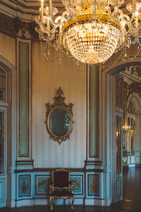 Illuminated chandelier hanging on ceiling of building