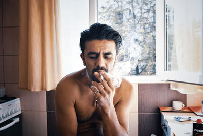 Portrait of young man sitting at home