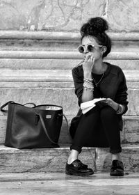 Full length of young woman sitting on seat