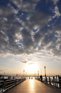 Bridge over sea against sky during sunset