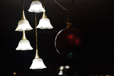 Low angle view of lit lamp hanging on ceiling