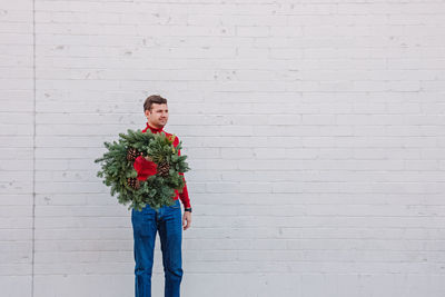 Portrait of smiling couple standing against wall