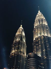 Low angle view of illuminated buildings against sky at night