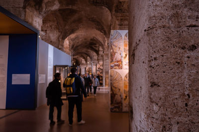 Rear view of people walking in corridor of building