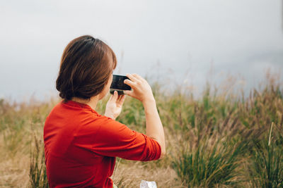 Rear view of woman photographing