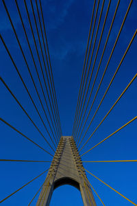 Low angle view of suspension bridge against sky