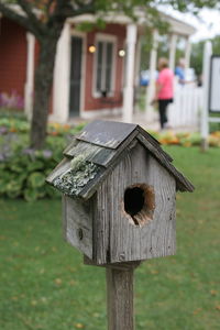 Close-up of birdhouse on wooden post in field