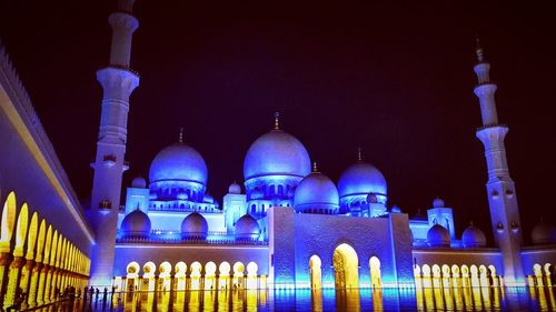 Low angle view of illuminated building against sky at night