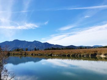 Scenic view of lake by mountains against sky