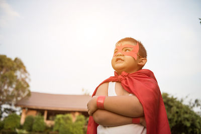 Boy with cape and eye patch playing in park