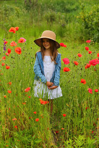 Portrait of woman with flowers on field