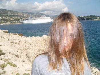 Portrait of woman at beach against sky