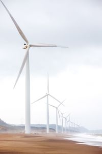 Windmill on landscape against sky