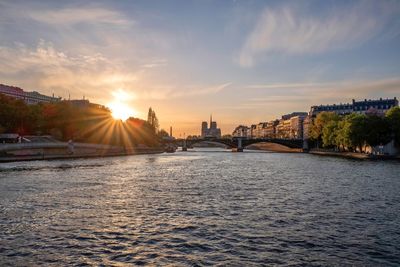 Bridge over river against sky during sunset