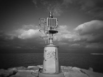 Close-up of communications tower on beach against sky