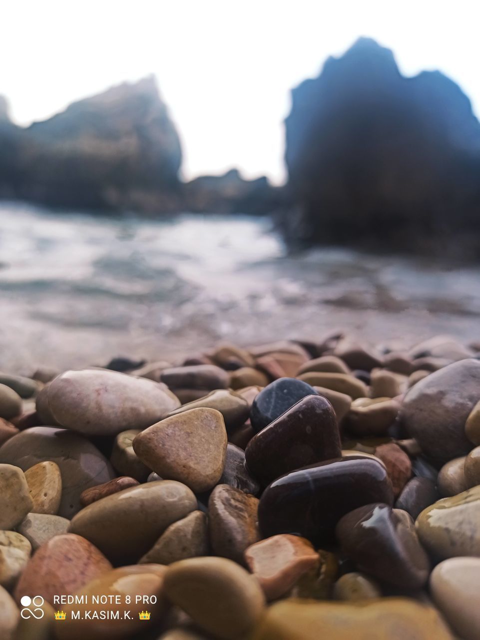 CLOSE-UP OF STONES ON SHORE AT BEACH