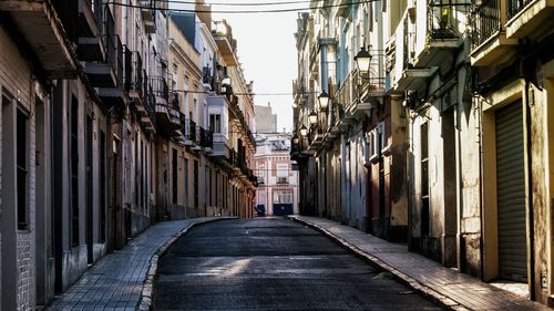 Walkway amidst city against sky