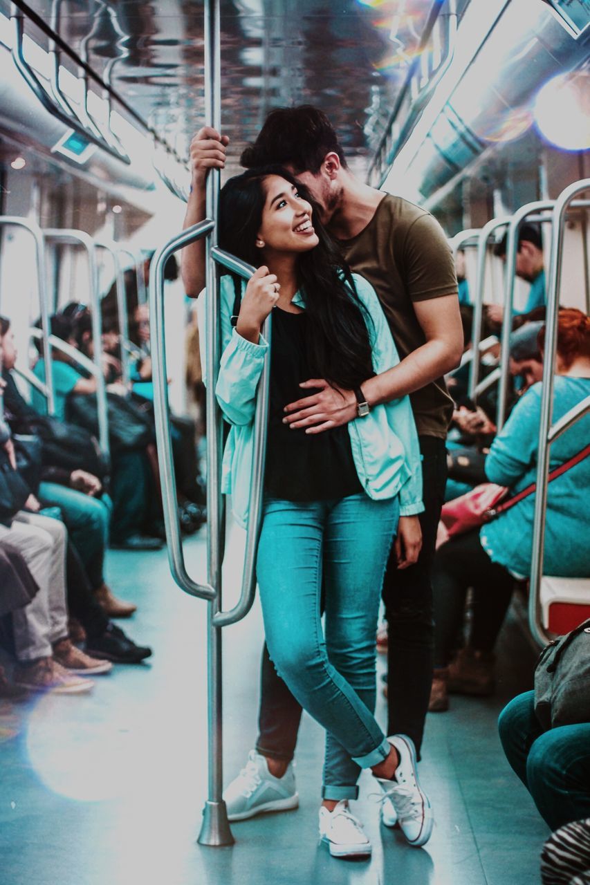 young adult, full length, real people, young women, lifestyles, front view, people, public transportation, incidental people, adult, rail transportation, transportation, leisure activity, women, casual clothing, mode of transportation, travel, hairstyle, indoors, subway train