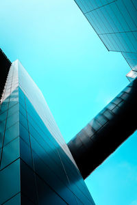 Low angle view of skyscrapers against clear blue sky