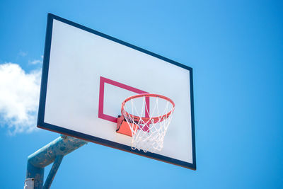 Low angle view of basketball hoop against blue sky