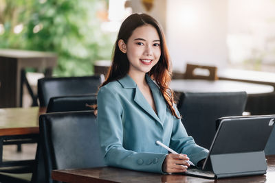 Young businesswoman using laptop while sitting at cafe