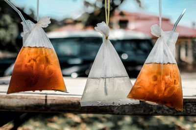 Close-up of drink in plastic bags hanging for sale