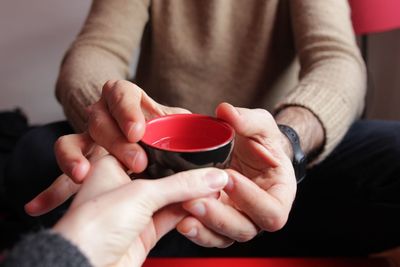 Close-up of woman giving water in bowl to man