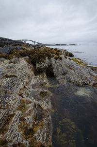 Scenic view of rocks in sea against sky