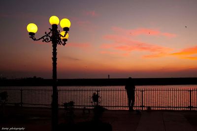 Silhouette of street light against sky at sunset