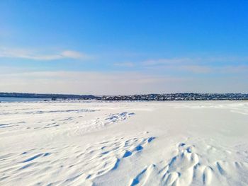 Scenic view of snow covered landscape against blue sky