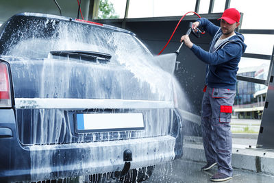 Low section of man washing car