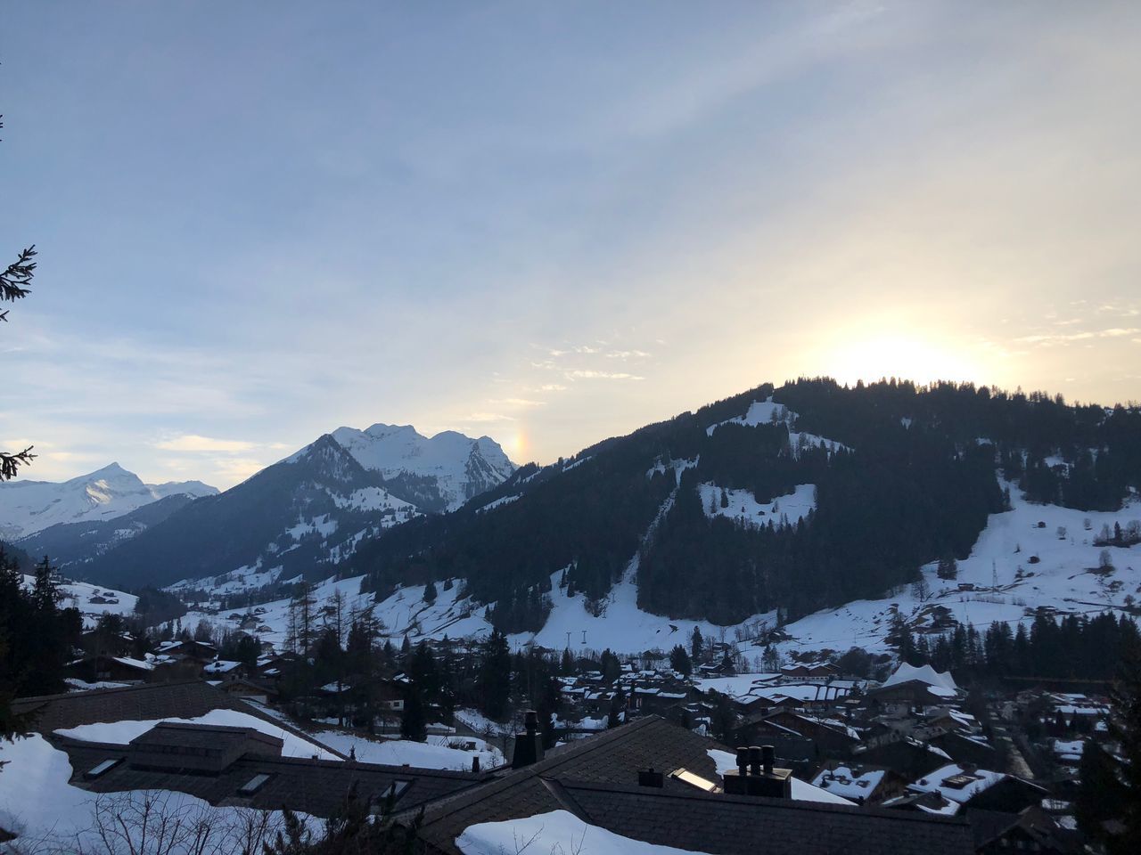 HOUSES AND MOUNTAINS AGAINST SKY DURING WINTER