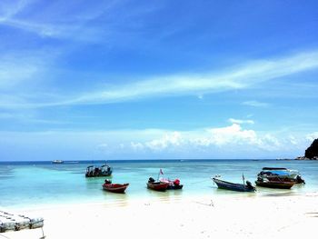 Boats moored on sea against sky