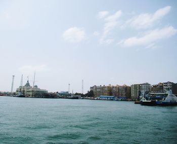 Scenic view of sea by buildings against sky