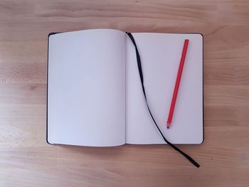 High angle view of open book and pencil on table