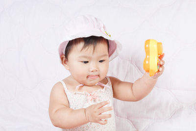 Cute baby girl sitting on bed at home