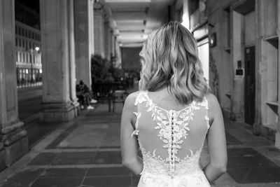 Rear view of woman standing at corridor of building