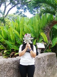 Woman with flowers on tree against plants