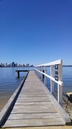 Wooden jetty leading to calm blue sea