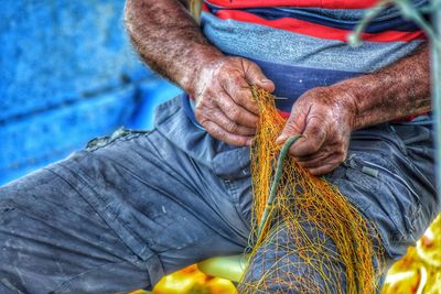Midsection of man holding fishing net