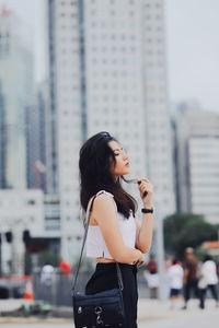 Side view of woman standing in city