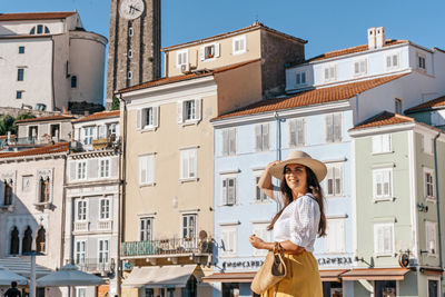 Stylish young woman standing in tartini square in idyllic town of piran, slovenia