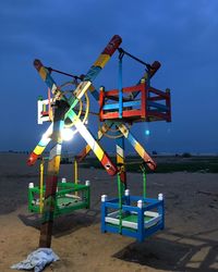 Traditional windmill on beach against blue sky