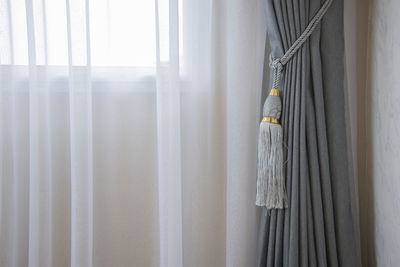 Close-up of curtain tied on window at home