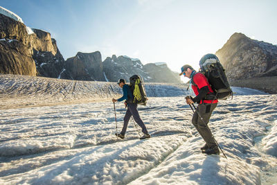Backpackers hike across glacier on baffin island.
