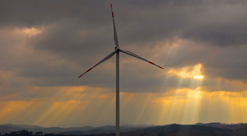 Low angle view of windmill against sky during sunset