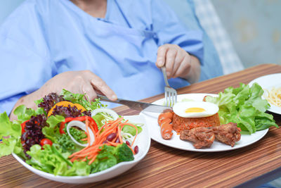 Midsection of man having food on table