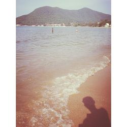 Scenic view of sea with mountain in background