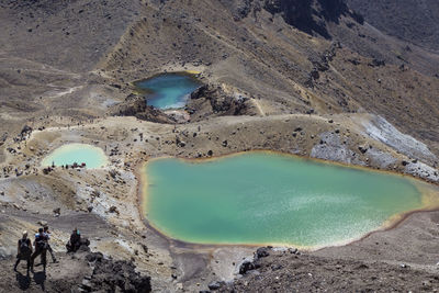 High angle view of people on rocks by lake