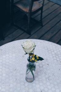 High angle view of white rose in vase on table